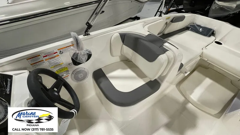 Slide: The Image of 2025 Bayliner E18LE boat interior with steering wheel and seating, Marine Center Indiana contact info. - 14