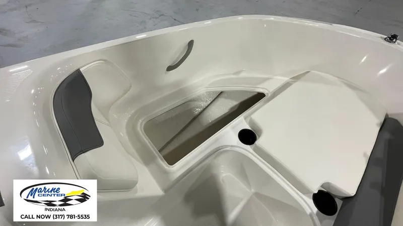Slide: The Image of 2025 Bayliner E18LE boat interior with seating and storage, Marine Center Indiana contact info visible. - 4