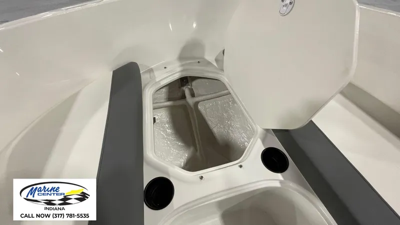 Slide: The Image of 2025 Bayliner E18LE boat storage compartment with open hatch, Marine Center Indiana logo. - 5