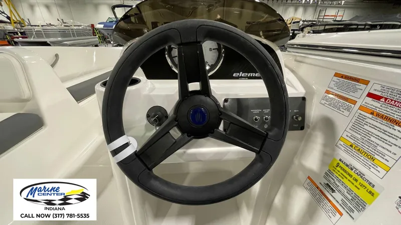 Slide: The Image of 2025 Bayliner E18LE boat steering wheel and dashboard with safety warnings. - 7