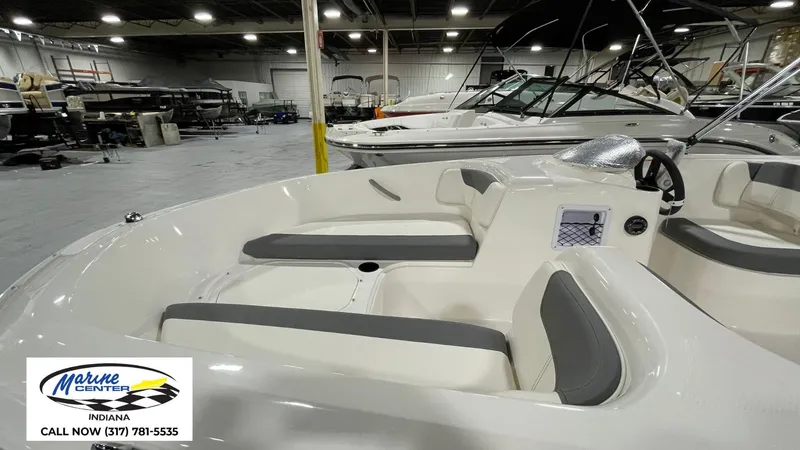 Slide: The Image of 2025 Bayliner E18LE boat interior in showroom, featuring sleek seating and modern design. - 8