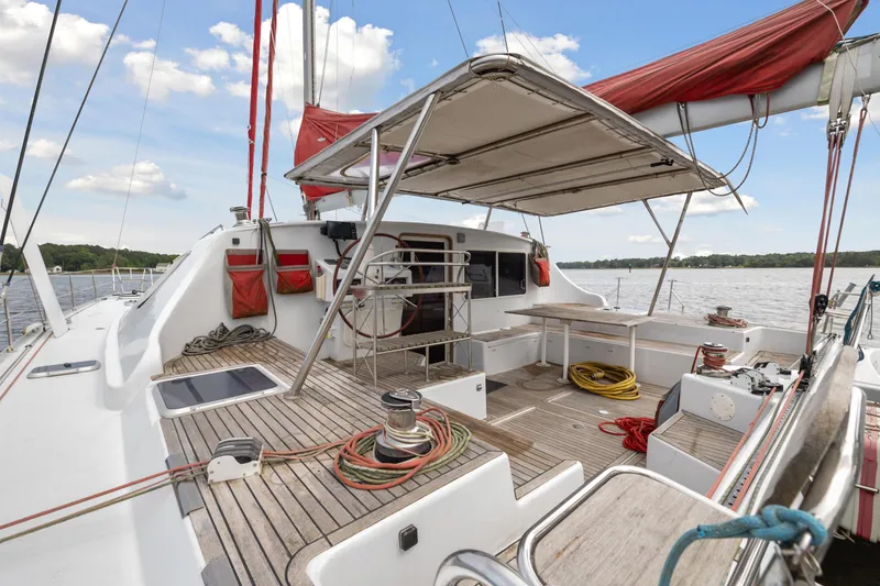 Slide: The Image of 2006 Switch 55 sailboat deck with red sails and spacious seating area. - 11
