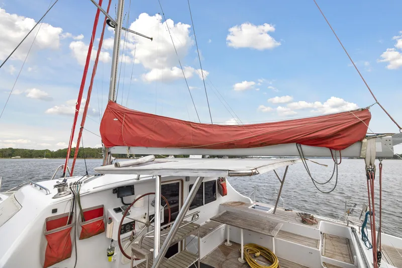 Slide: The Image of Sailboat Switch 55 (2006) with red sail cover on calm water. - 13