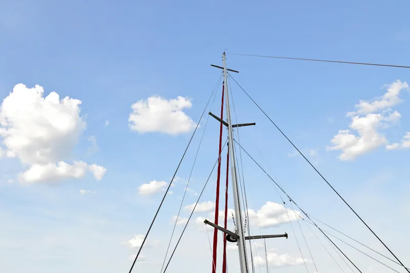 Slide: The Image of Sailboat mast of a 2006 Switch 55 against a blue sky with clouds. - 15