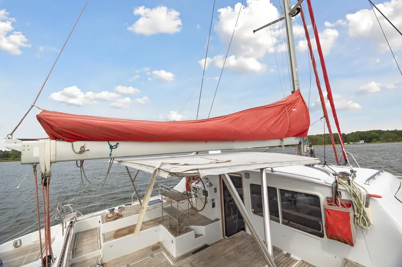 Slide: The Image of 2006 Switch 55 sailboat with red sail cover on deck, docked on a sunny day. - 18