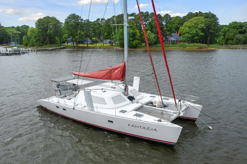 Slide: The Image of White Switch 55 catamaran sailboat from 2006 named Fantazia on a calm lake. - 2