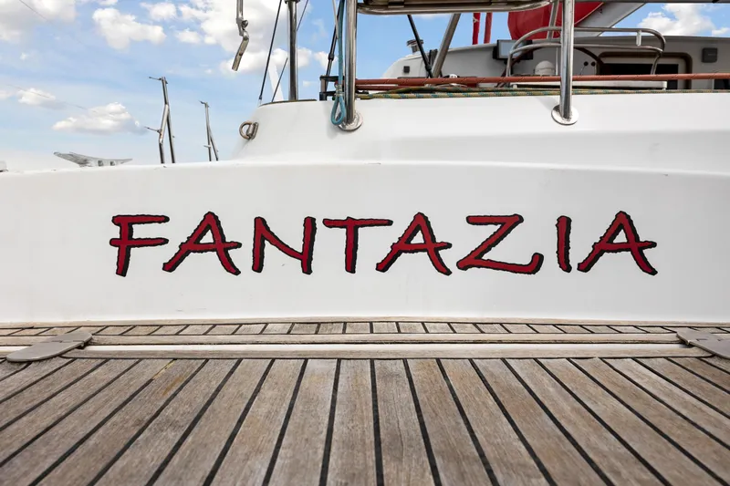Slide: The Image of Fantazia boat name on Switch 55 yacht, 2006 model, docked with wooden deck. - 22