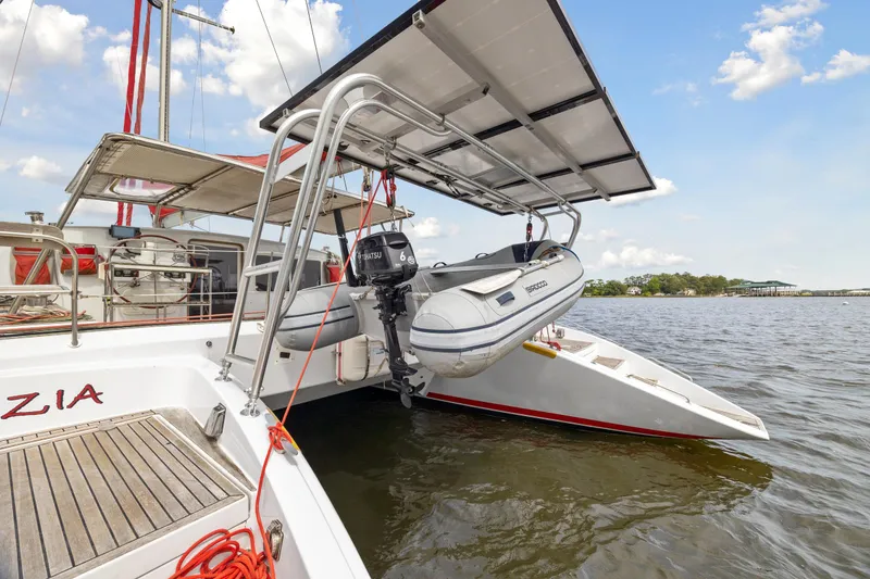 Slide: The Image of Catamaran Switch 55 (2006) with dinghy and solar panels on water. - 27