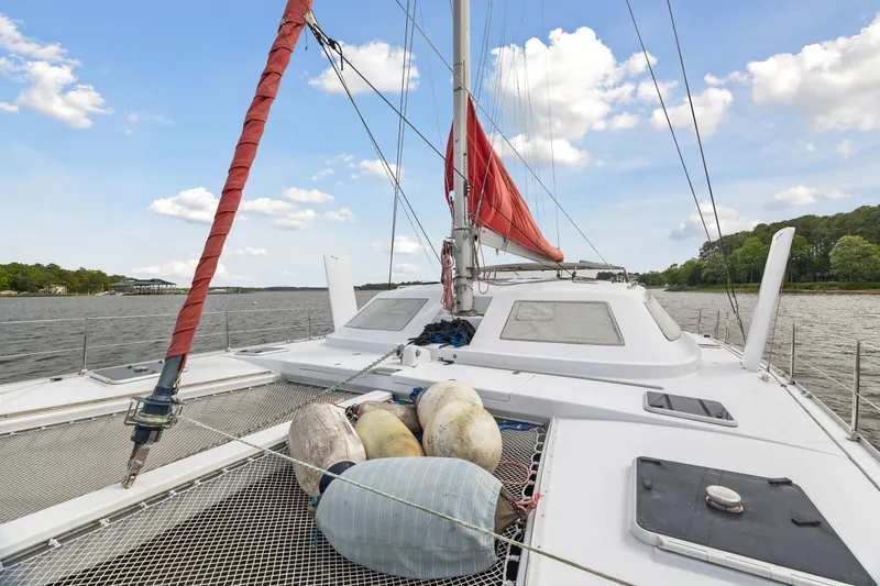 Slide: The Image of Sailing catamaran Switch 55 (2006) with red sail on calm waters under blue sky. - 32