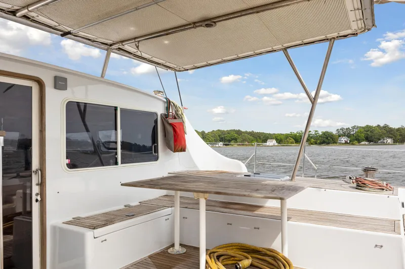 Slide: The Image of Deck of 2006 Switch 55 catamaran with table, seating, and scenic water view. - 33