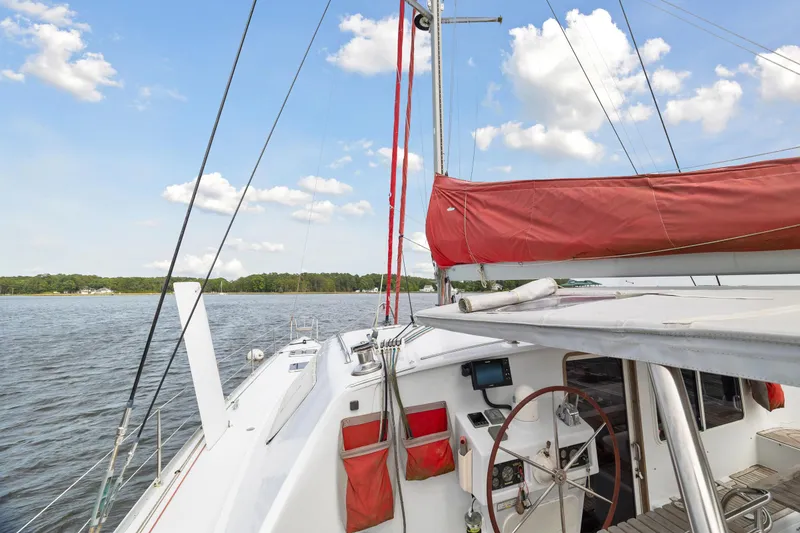 Slide: The Image of Sailing yacht Switch 55 (2006) with red sail on calm waters under blue sky. - 44