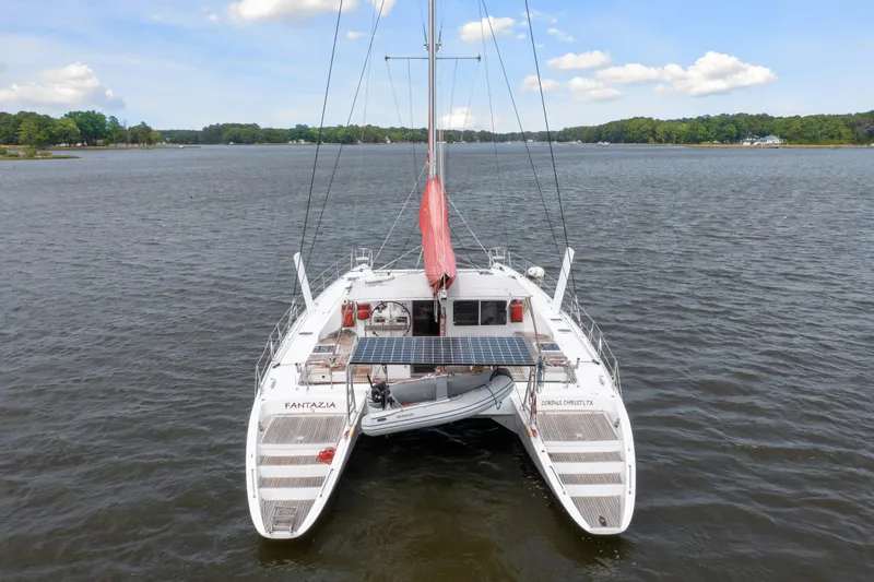 Slide: The Image of Catamaran Switch 55 (2006) with red sail on calm lake, aerial view. - 5