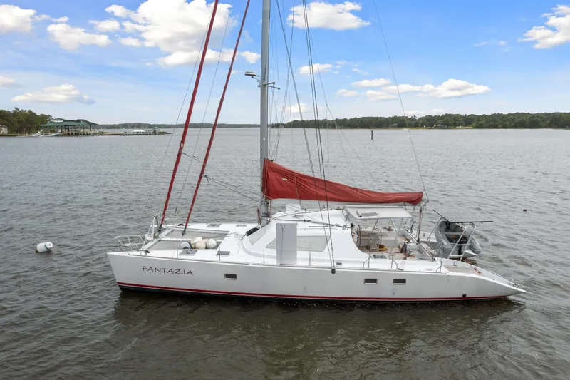 Slide: The Image of 2006 Switch 55 sailboat Fantazja on calm waters with red sails. - 7