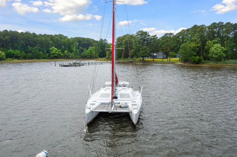 Slide: The Image of White Switch 55 catamaran anchored on a serene lake, surrounded by lush greenery. - 8
