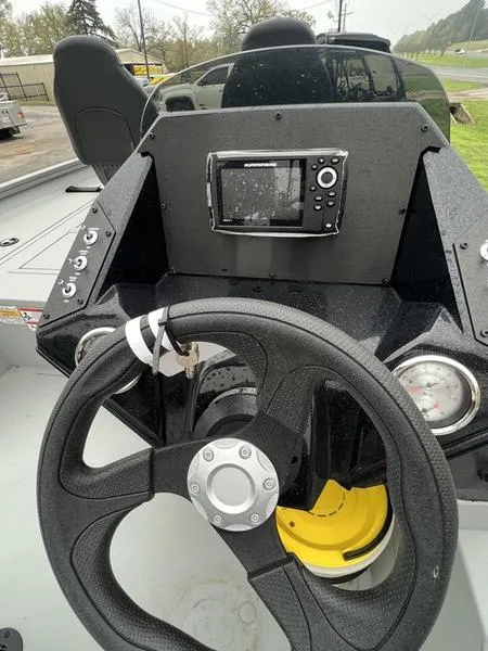 Slide: The Image of 2023 Crestliner XFC 179 boat dashboard with steering wheel and navigation system. - 2