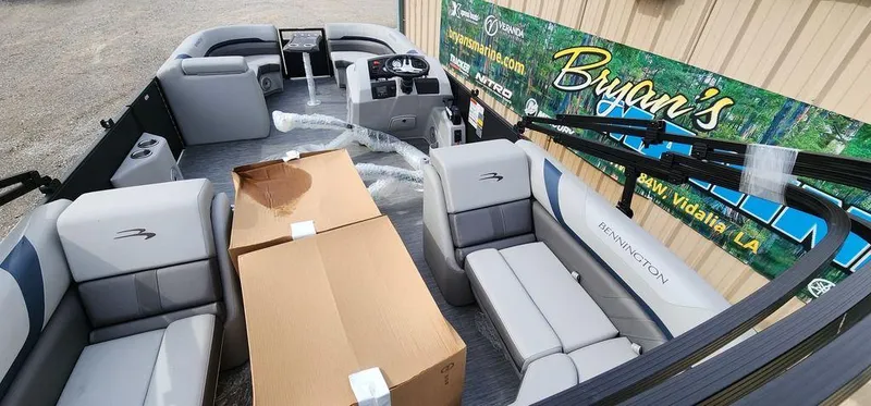 Slide: The Image of 2023 Bennington 23 SXSR pontoon boat interior with seating and cardboard boxes. - 11