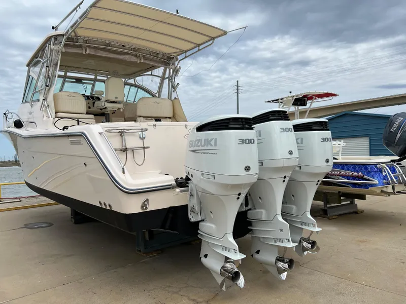 Slide: The Image of 2007 Grady-White Express 360 boat with triple Suzuki 300 engines, docked under cloudy skies. - 1