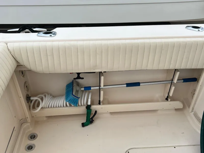 Slide: The Image of 2007 Grady-White Express 360 boat storage area with cleaning tools and hose. - 24