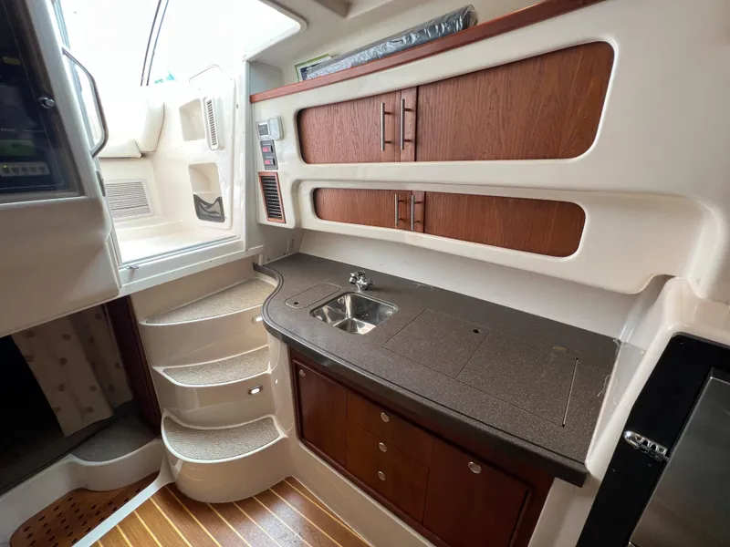 Slide: The Image of 2007 Grady-White Express 360 interior with wooden cabinetry, compact sink, and staircase. - 32