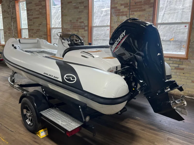 Slide: The Image of 2023 Walker Bay Generation 450 boat with Mercury engine on trailer indoors. - 2