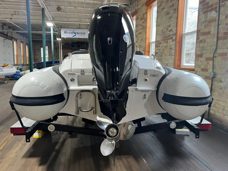 Slide: The Image of 2023 Walker Bay Generation 450 boat with outboard motor, displayed indoors on a trailer. - 3