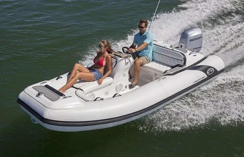 Slide: The Image of 2023 Walker Bay Generation 450 boat cruising with two passengers on a sunny day. - 5