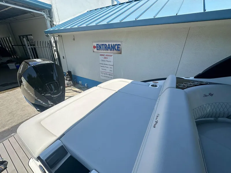 Slide: The Image of 2023 Sea Ray SLX 260 Outboard boat near entrance sign, showcasing sleek design. - 14