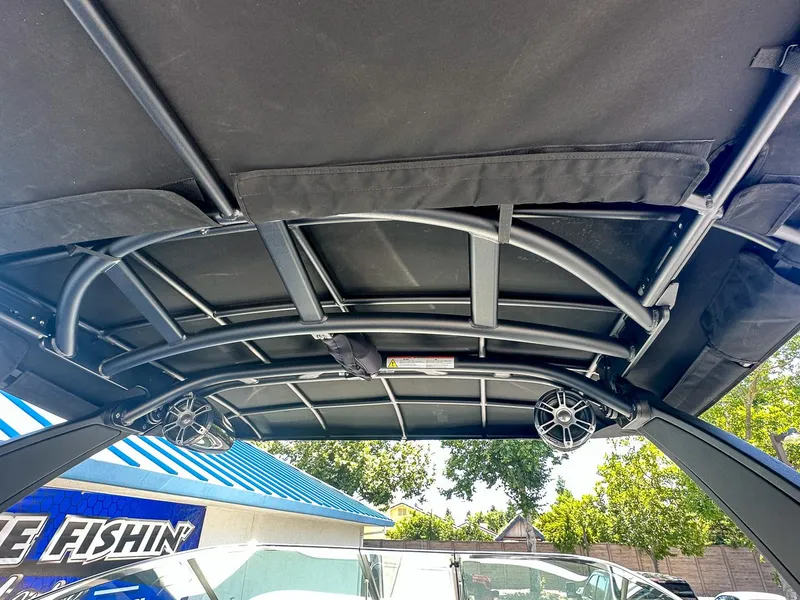 Slide: The Image of 2023 Sea Ray SLX 260 Outboard boat canopy with speakers, outdoor setting. - 15