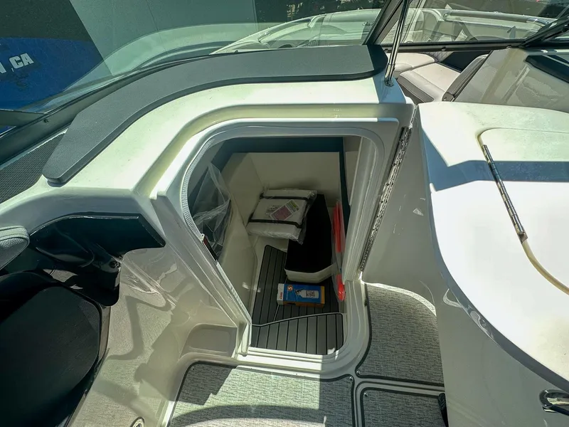 Slide: The Image of 2023 Sea Ray SLX 260 Outboard interior storage compartment with items inside. - 18