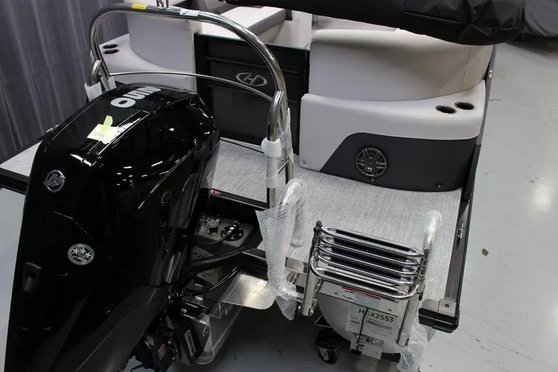 Slide: The Image of 2023 Harris Cruiser 250 CWDH boat with outboard motor and swim ladder. - 5