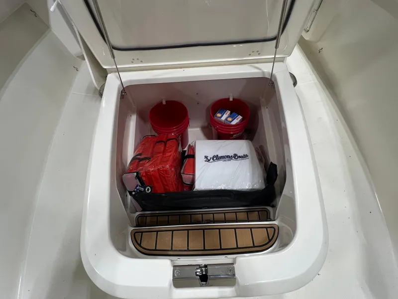 Slide: The Image of Storage compartment on 2025 Boston Whaler 280 Outrage with safety gear and supplies. - 11