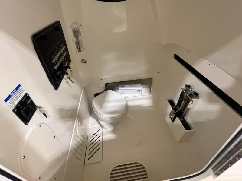 Slide: The Image of Interior of 2025 Boston Whaler 280 Outrage boat, featuring a compact marine toilet. - 12