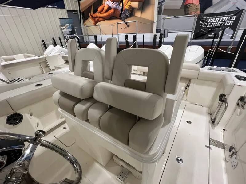 Slide: The Image of 2025 Boston Whaler 280 Outrage boat interior with cushioned seating and steering wheel. - 6