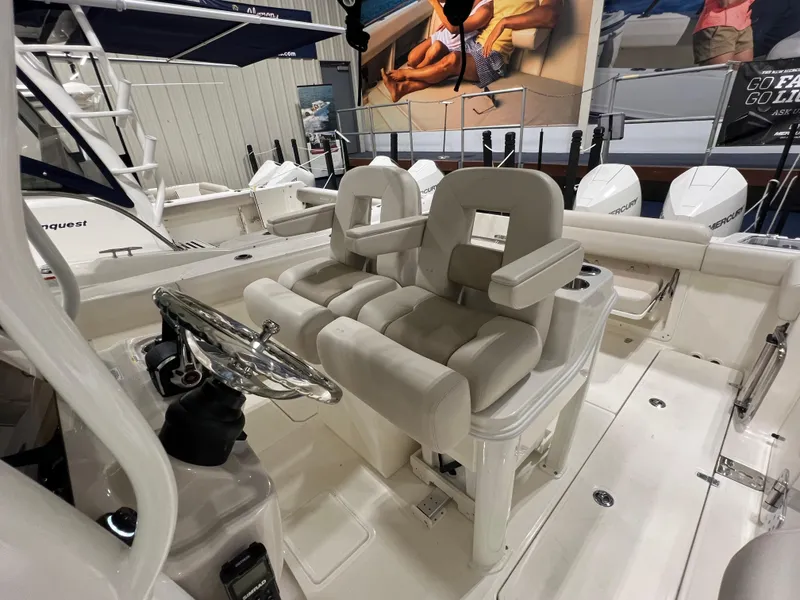 Slide: The Image of 2025 Boston Whaler 280 Outrage boat interior with dual helm seats and steering wheel. - 7