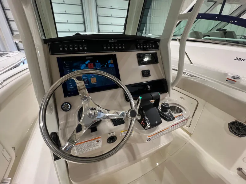 Slide: The Image of 2025 Boston Whaler 280 Outrage helm with advanced navigation controls and steering wheel. - 8