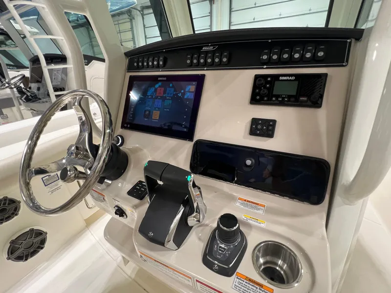 Slide: The Image of 2025 Boston Whaler 280 Outrage dashboard with advanced controls and navigation system. - 9