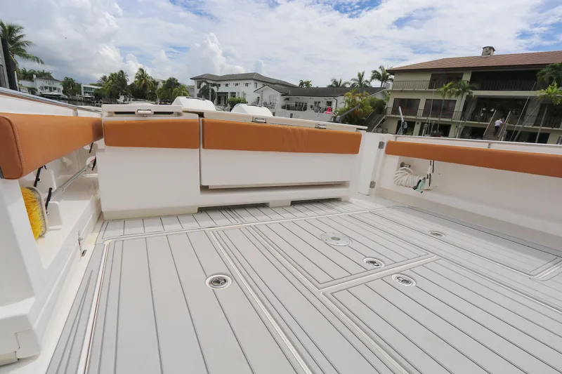 Slide: The Image of 2018 Belzona 327wa boat deck with tan seating, docked near waterfront homes. - 11