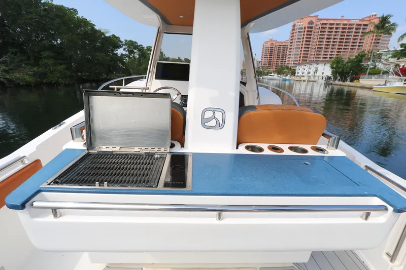 Slide: The Image of 2018 Belzona 327wa boat with outdoor grill and seating, docked near waterfront buildings. - 2
