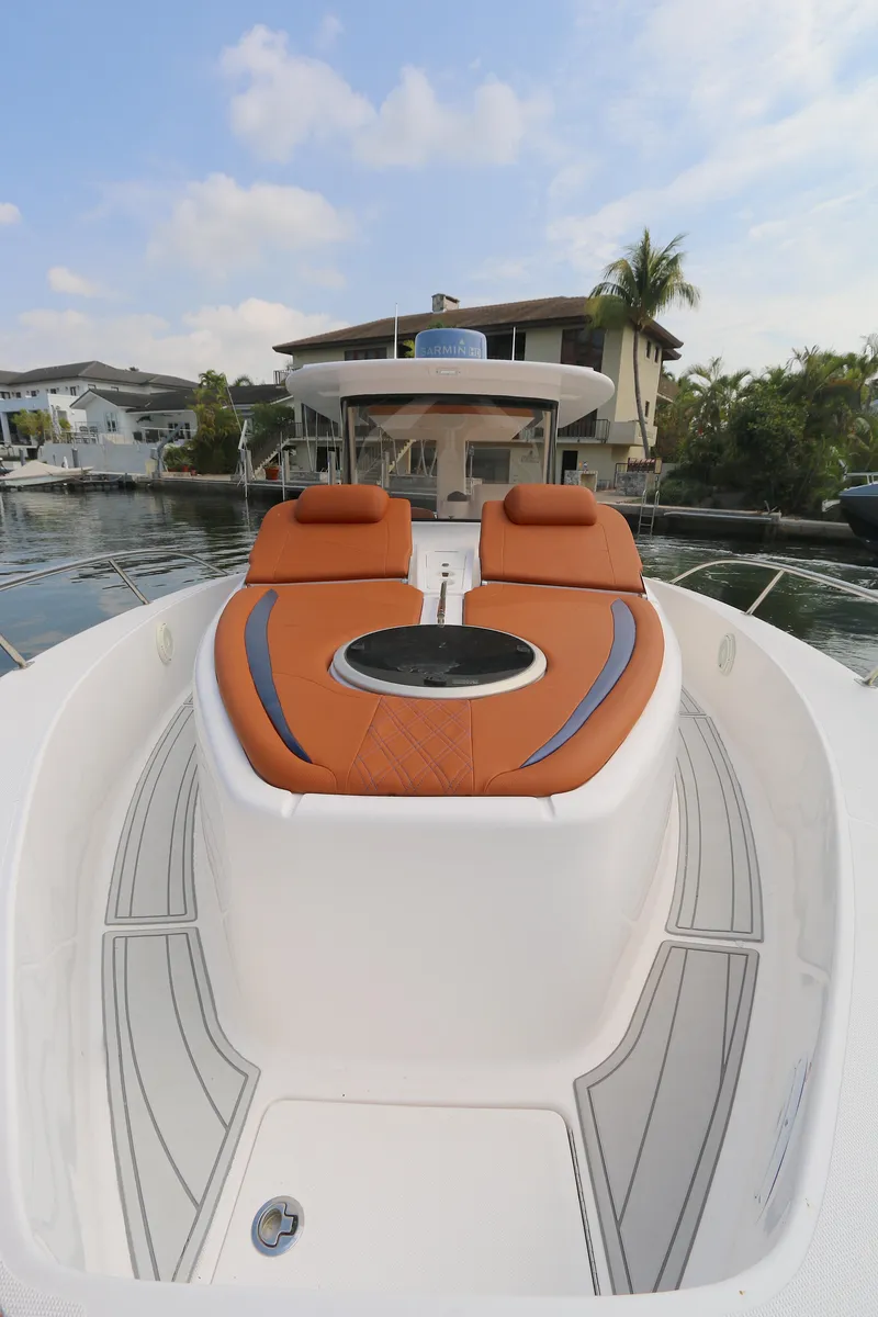 Slide: The Image of 2018 Belzona 327wa boat with orange seating, docked near waterfront homes. - 7