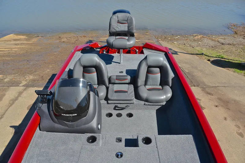 Slide: The Image of 2021 Tracker 175 TXW boat with gray seating and red accents at a lakeside dock. - 21