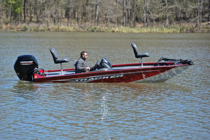 Slide: The Image of 2021 Tracker 175 TXW boat on a calm lake with a Mercury engine. - 7