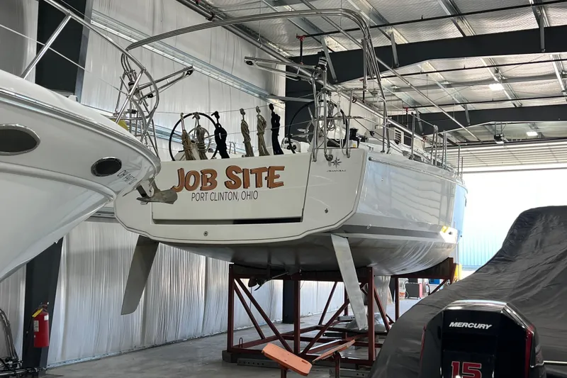 Slide: The Image of 2023 Jeanneau Sun Odyssey 380 sailboat named "Job Site" in a storage facility. - 10