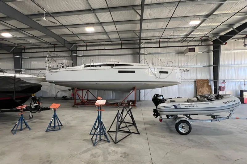 Slide: The Image of 2023 Jeanneau Sun Odyssey 380 sailboat in indoor storage, alongside a small inflatable boat. - 11