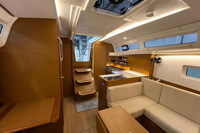 Slide: The Image of Luxurious interior of 2023 Jeanneau Sun Odyssey 380 sailboat with modern kitchen and seating area. - 14