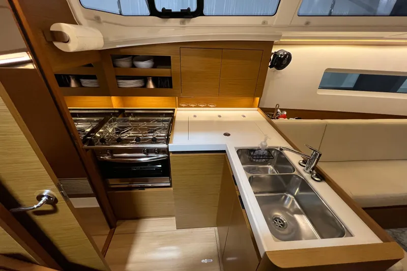 Slide: The Image of Modern kitchen interior of 2023 Jeanneau Sun Odyssey 380 yacht, featuring sleek design and amenities. - 15