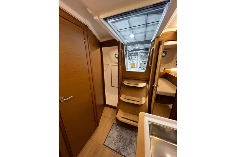 Slide: The Image of Interior of 2023 Jeanneau Sun Odyssey 380 yacht, featuring wooden cabinetry and modern design. - 17