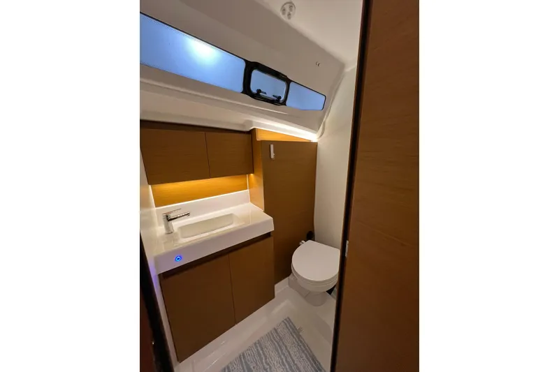 Slide: The Image of Modern bathroom interior of 2023 Jeanneau Sun Odyssey 380 yacht, featuring sleek design and wood accents. - 23