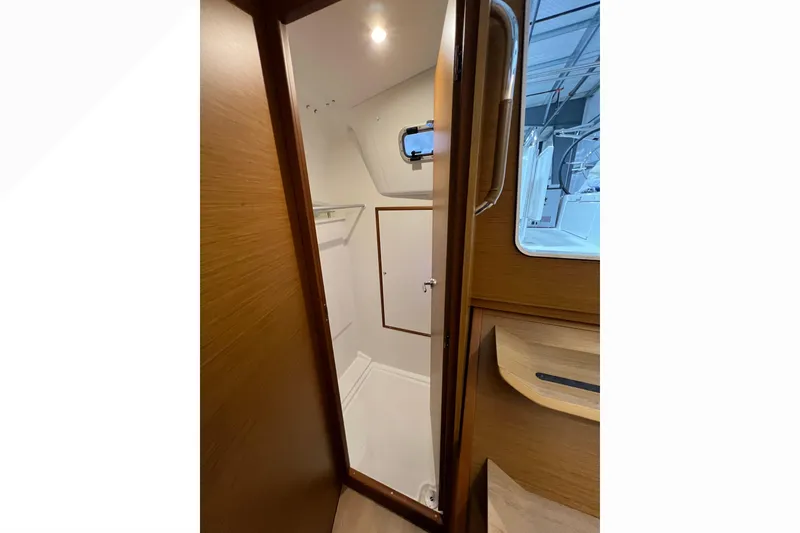 Slide: The Image of Interior view of 2023 Jeanneau Sun Odyssey 380 sailboat bathroom with wooden door and window. - 24