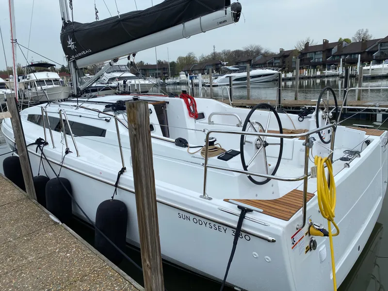 Slide: The Image of 2023 Jeanneau Sun Odyssey 380 sailboat docked at marina, featuring dual steering wheels. - 5