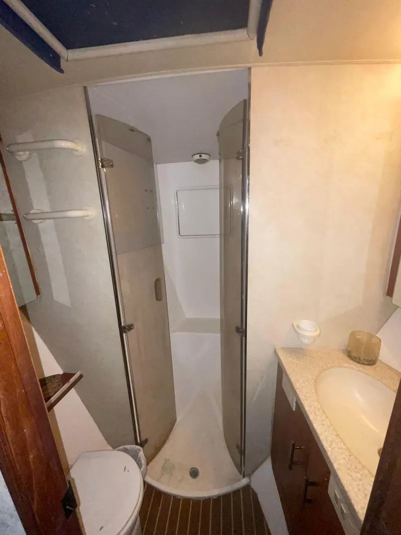 Slide: The Image of Bathroom interior of a 2000 Ocean Yachts Convertible, featuring a shower, sink, and toilet. - 10